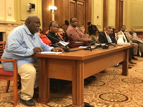 Individuals give testimony at table in DC Council Chambers