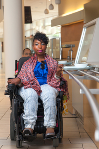 Andraea in a power chair in a cafeteria 