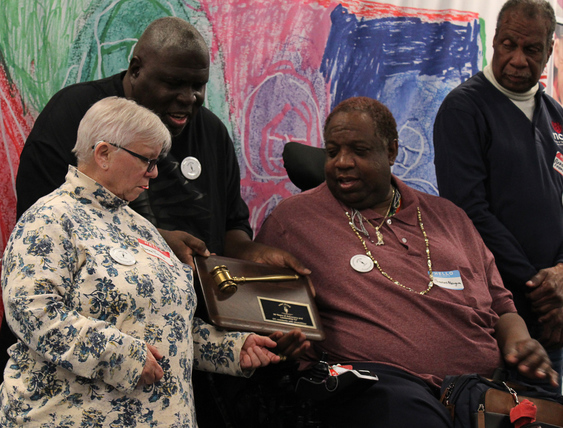 Project ACTION! Members together with a plaque