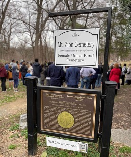 Entrance to Mt Zion and Female Union Band Cemeteries, marked by an entrance sign, with a tour shown in the background