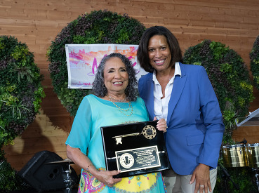 Photo of Mayor Bowser and Cathy Hughes with the Key to the City. 