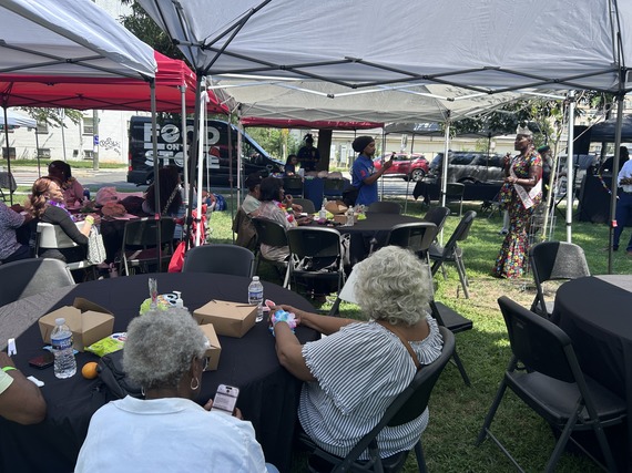 Photo from a recent Senior Mix and Mingle event with attendees sitting at tables at an outdoor event space.