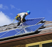 Man installing solar panels on a home