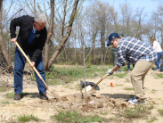 DNREC Secretary Shawn M. Garvin, left, works with a colleague to plant another tree in the Tree for Every Delawarean Initiative
