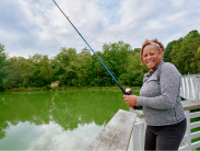 Woman smiling while fishing from a pier
