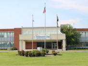 Exterior view of the Delaware City Refinery building with three flagpoles in front.