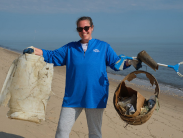Volunteer holds up collected trash at the 2025 Delaware Coastal Cleanup event.