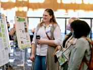 3 women stand looking at exhibits at the 10th Delaware Wetlands Conference.
