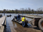 Volunteers work from a boat to remove trash collected during an earlier Christina River Watershed Cleanup.
