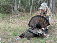 Young girl posing with her harvested turkey during hunting season in Delaware.