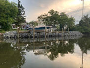 A motorboat sits beside an empty wooden dock along the Lewes-Rehoboth Canal