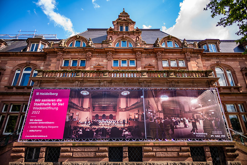 Ein neues Banner am Portikus der Heidelberger Stadthalle weist auf die derzeitige Sanierung hin. (Foto: Dittmer)