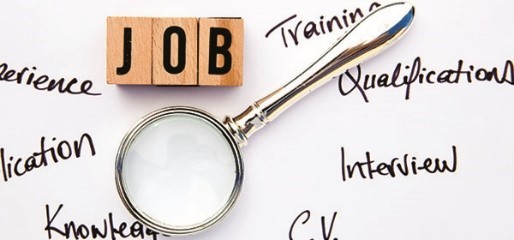 Job spelled in scrabble tiles above a magnifying glass surrounded by career words