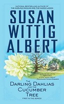 The Darling Dahlias and the Cucumber Tree by Susan Wittig Albert book cover - two homes with a bare tree and dahlia in front