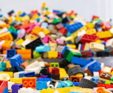 Tilted bucket with legos falling out across a table