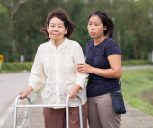 a person helping a woman with a cane