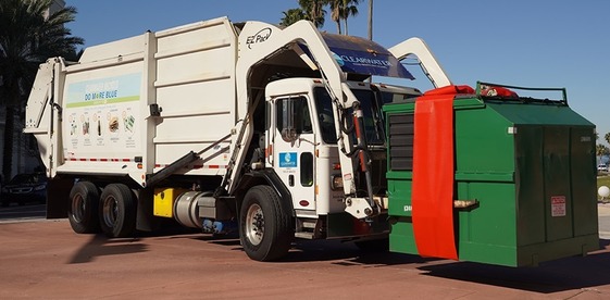Waste Truck with dumpster wrapped in red holiday bow
