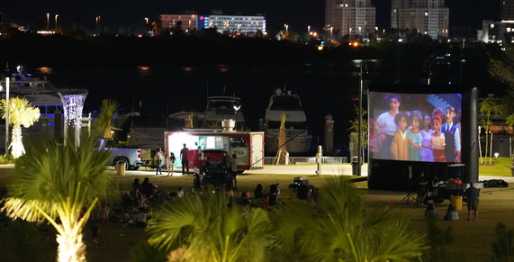 people watching a movie at coachman park grass