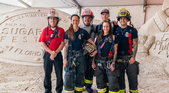 fire and rescue staff in front of sand castle