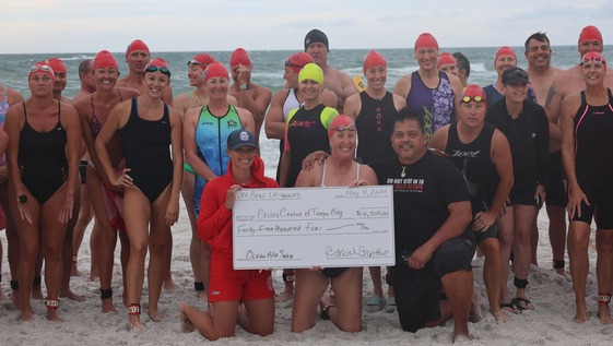 Group of swimmers holding a check