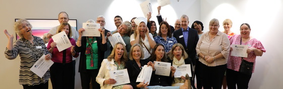 a group of people holding certificates