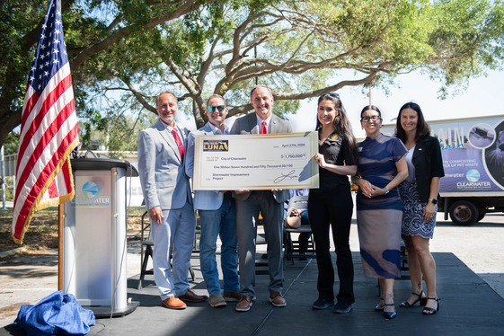 Group photo of Representative Luna, Mayor Rector, City Manager, Vice Mayor, and council members accepting a check. 