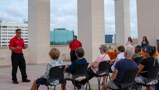 Image of firefighters talking to people on library rooftop