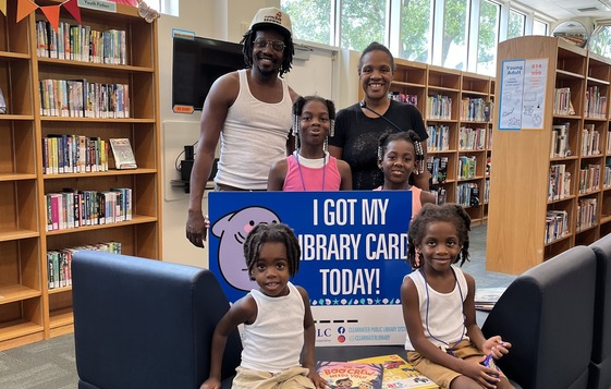 A family holding a giant library card