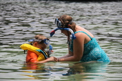 kid in life jacket and mom assisting