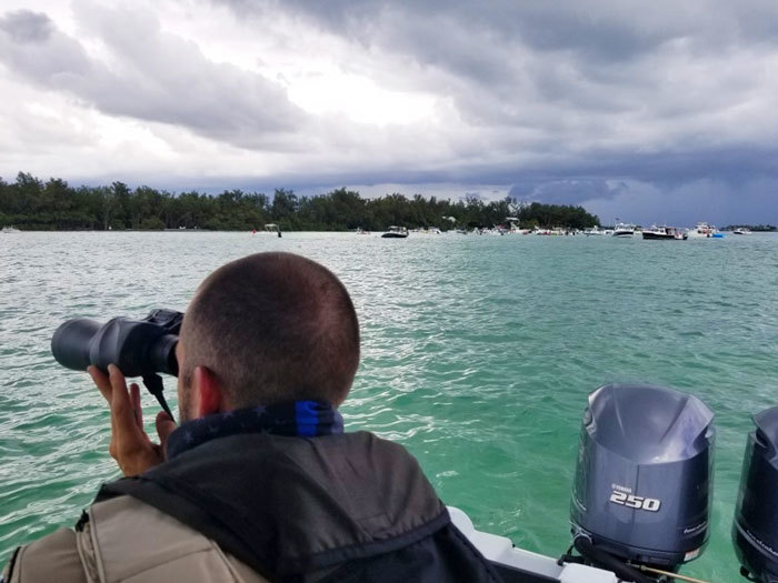 officer on boat looking through binoculars