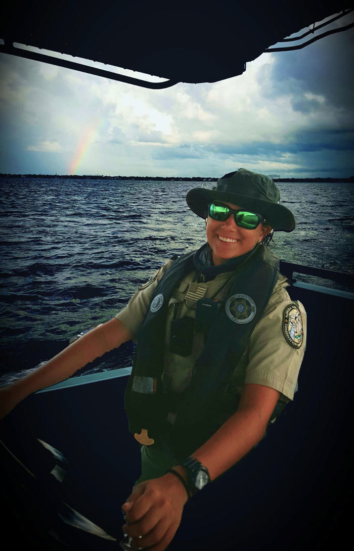 officer on boat with rainbow in background