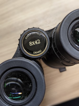 A pair of binoculars with the numbers "8x42"