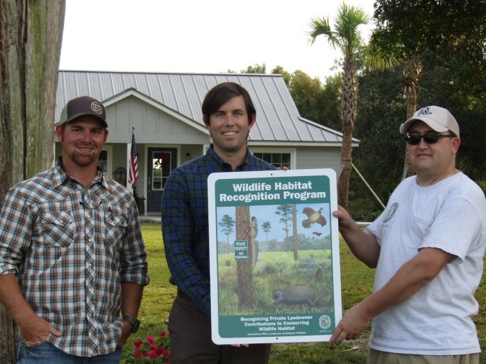 three men with plaque