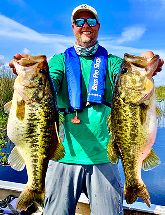 Biologist holding two trophy Florida largemouth bass