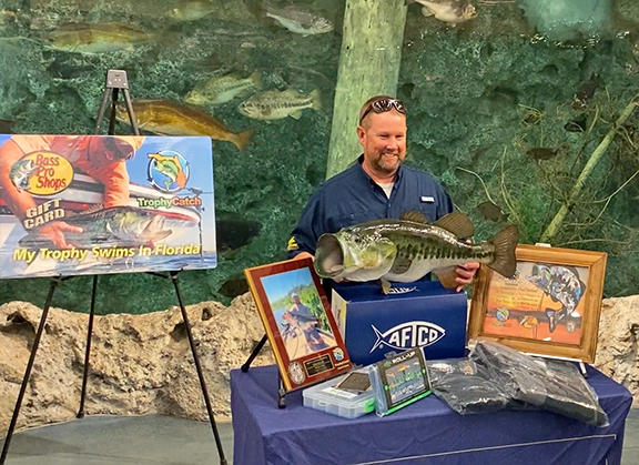 Angler with trophy Florida bass mount and prizes