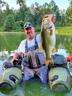 Angler in float tube with trophy Florida largemouth bass