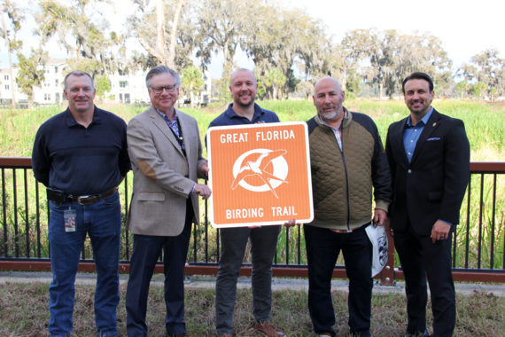 Five smiling people holding a Great Florida Birding and Wildlife Trail sign.
