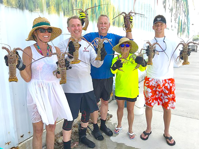 group of people holding lobsters