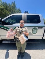 FWC officer holding bags of red snapper fillets, a violation of not landing in whole condition