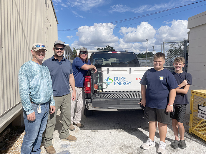 staff and students in front of truck