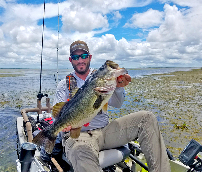 angler in boat holding trophy size Florida bass