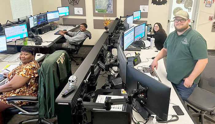 FWC employees sitting and standing in front of rows of computer screens