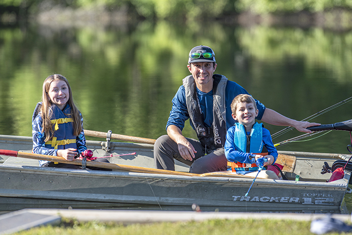 dad and two kids fishing from boat