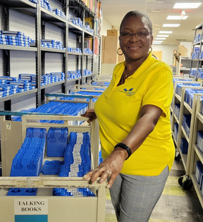 Felicia Brown with a cart full of Talking Books audiobooks