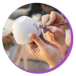 Person painting a flowerpot