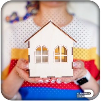 A woman holding a miniature wooden house