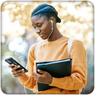 Young teen enjoying an audiobook outdoors