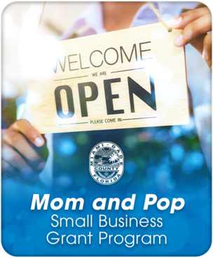 A woman flips the "Open" sign on a store