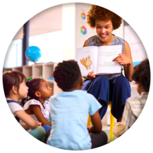 Teacher reading a story aloud to a group of young students