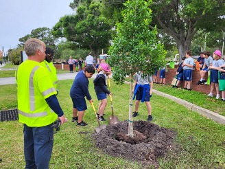 Students planting a tree at Joe Davis Community Center